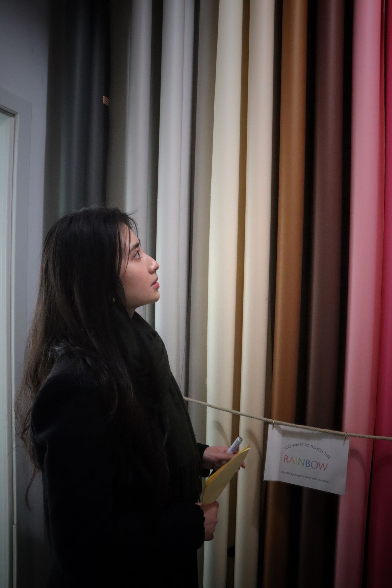 Illustrative stock photograph of a visitor choosing curtain fabrics; not the actual Uttara gallery
